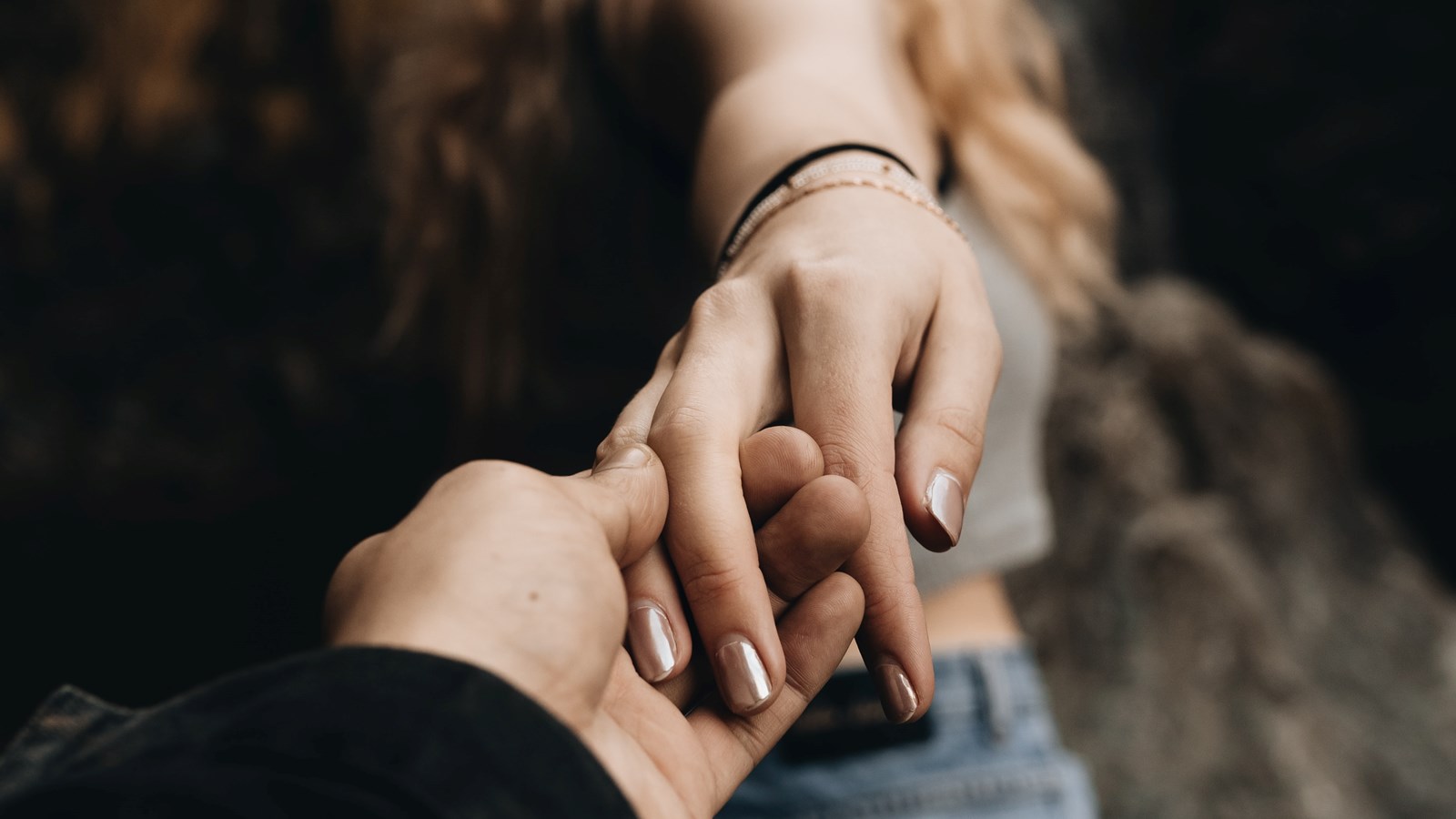 Kvinnas hand som försiktigt glider ur en mans hand